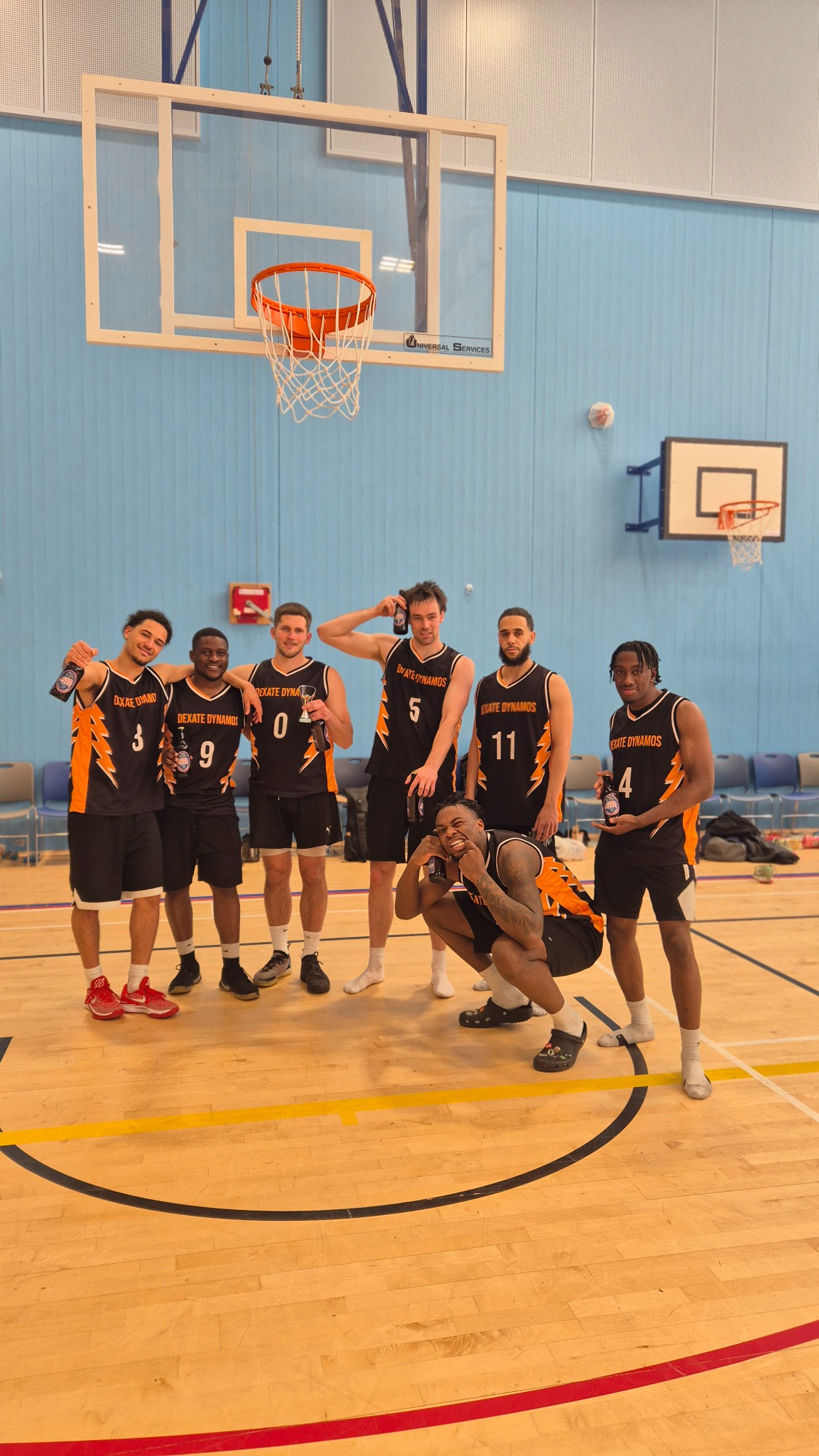 Tournament Runner up: Dexate Dynamos A group of seven basketball players in uniforms posing together indoors.