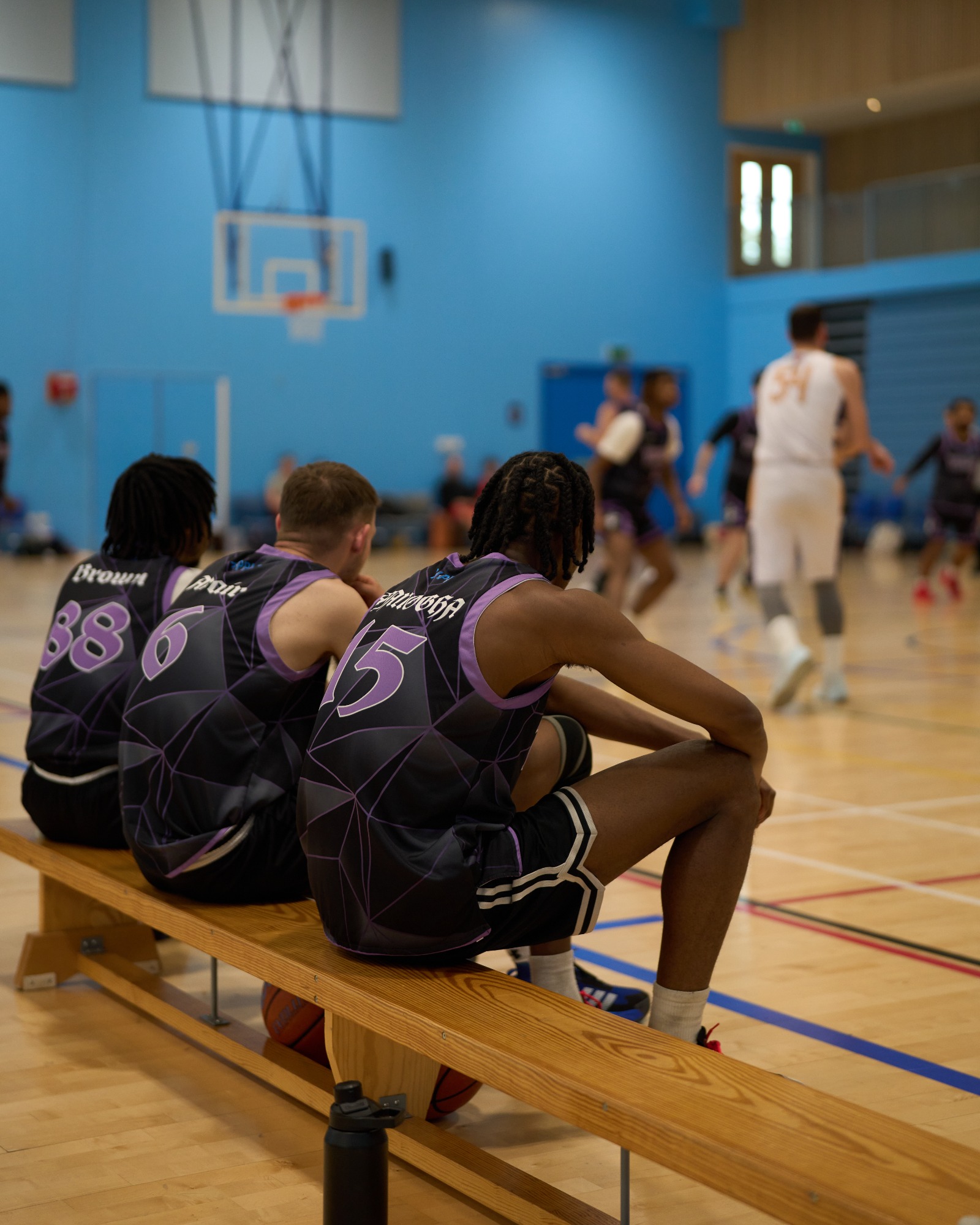 Stylistic shot of team bench watching basketball game.