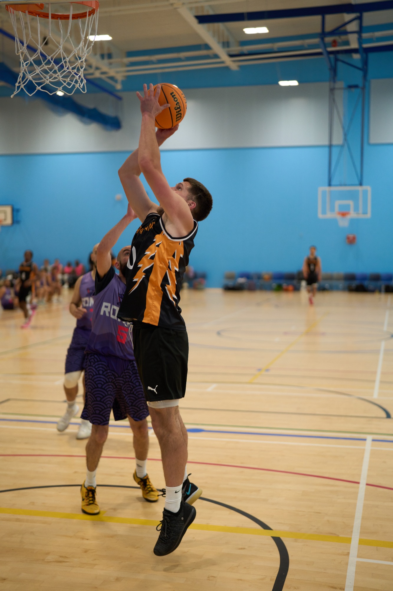 Side on close up of player mid air shooting the basketball.
