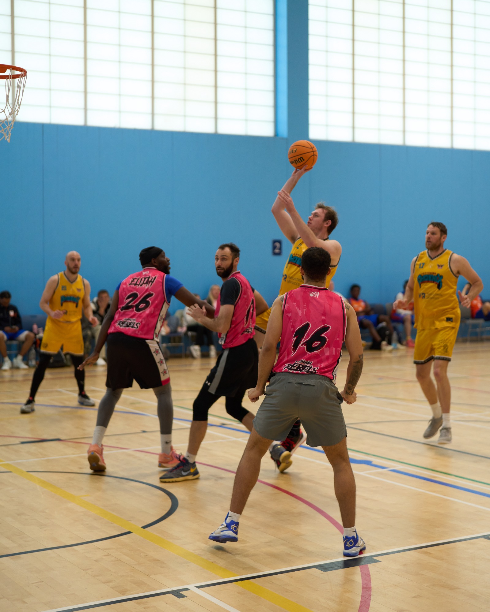 Basketball player taking a floating shot, driving into the key.