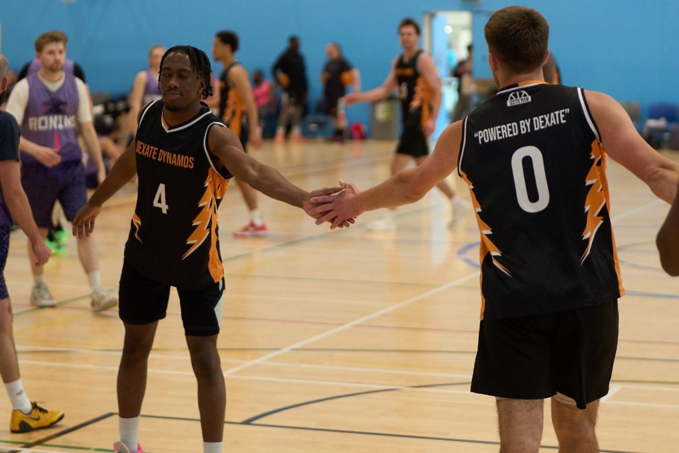 Two basketball players greeting each other on the court during a game.