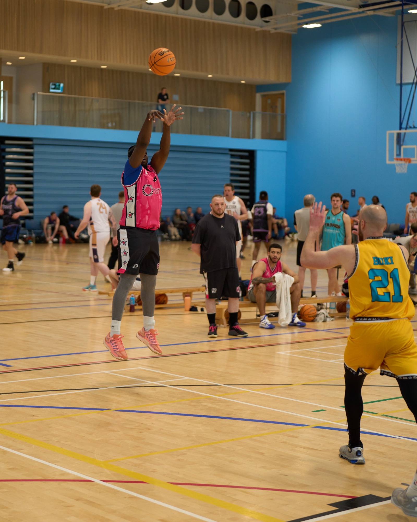 Basketball player shooting a 3 point jump shot on the edge of the three arc.