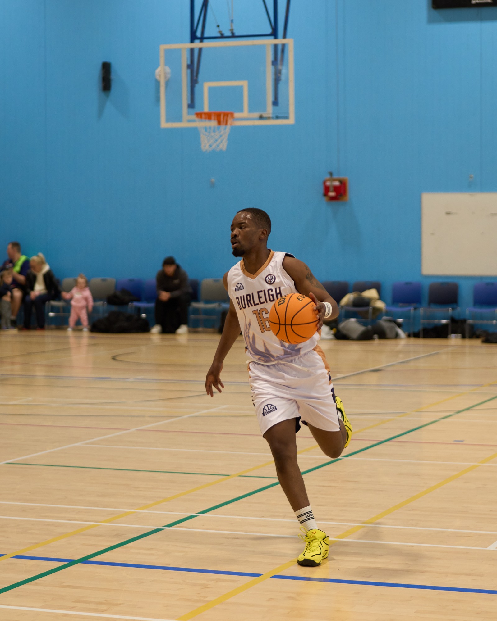 Front on of a player dribbling the basketball on one leg.