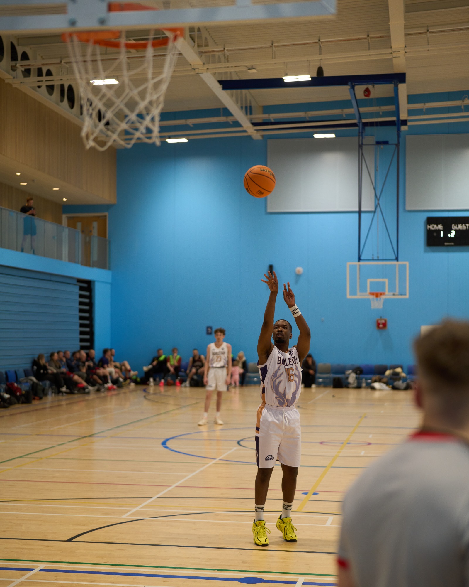 Player taking a free throw shot with the basket in view.