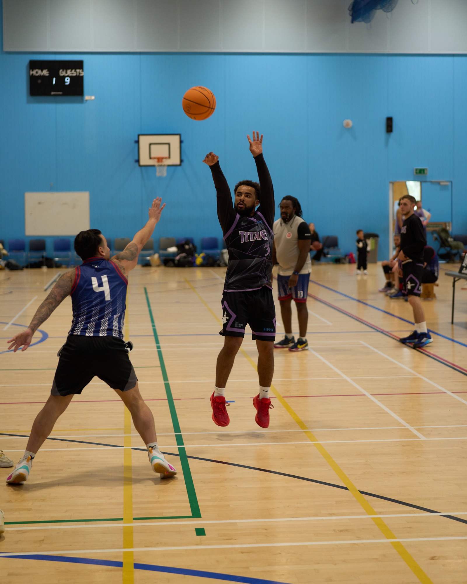 A basketball player shoots while another defends at the 3 point line.