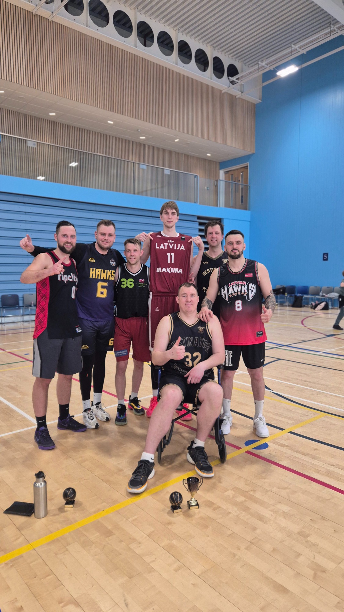 Tournament Winners: Latvian Hawks A group of six basketball players posing together in a sports hall.