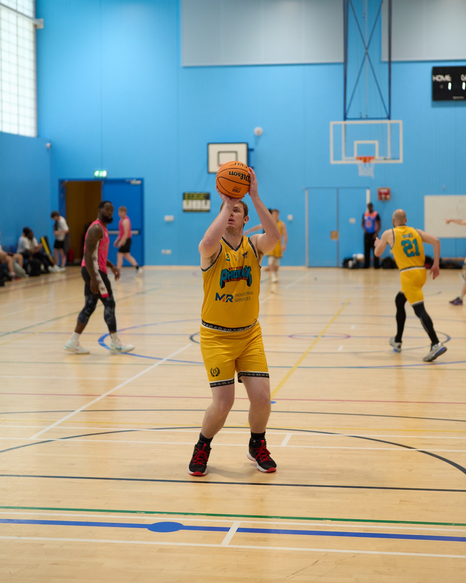 Front on view of a free throw shot attempt being made in a basketball tournament.