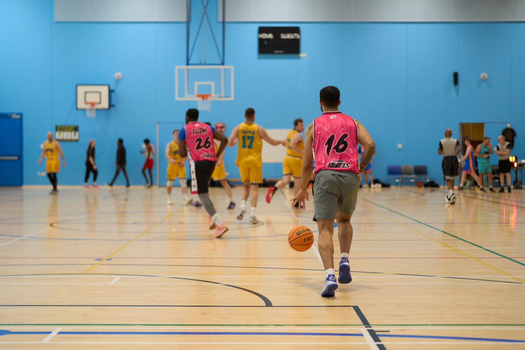 Baseline shot of a player dribbling the basketball towards opposition.