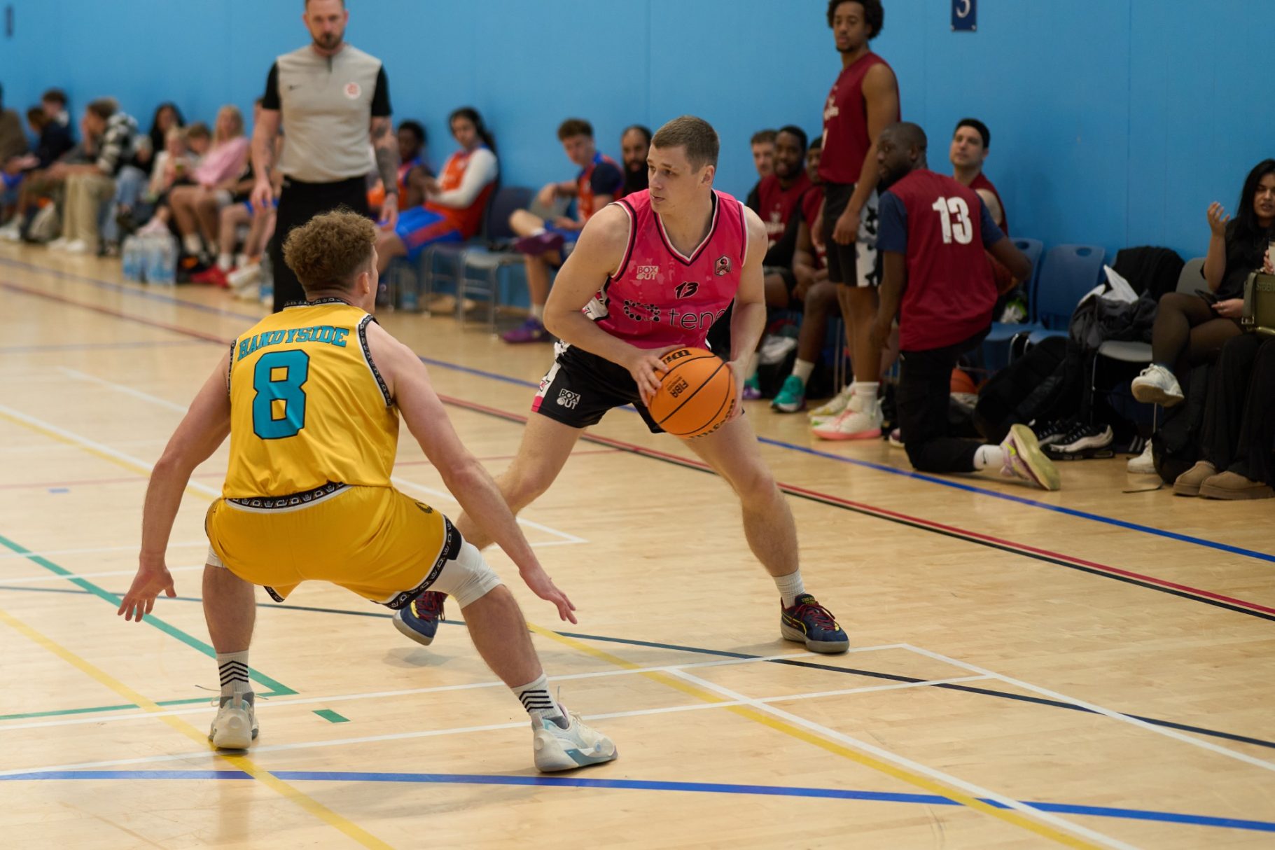 Close up of a player defending another with basketball in hand.