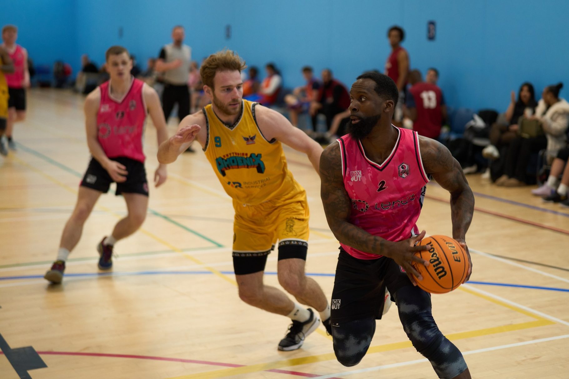Close up of player attacking the basket with defender behind.
