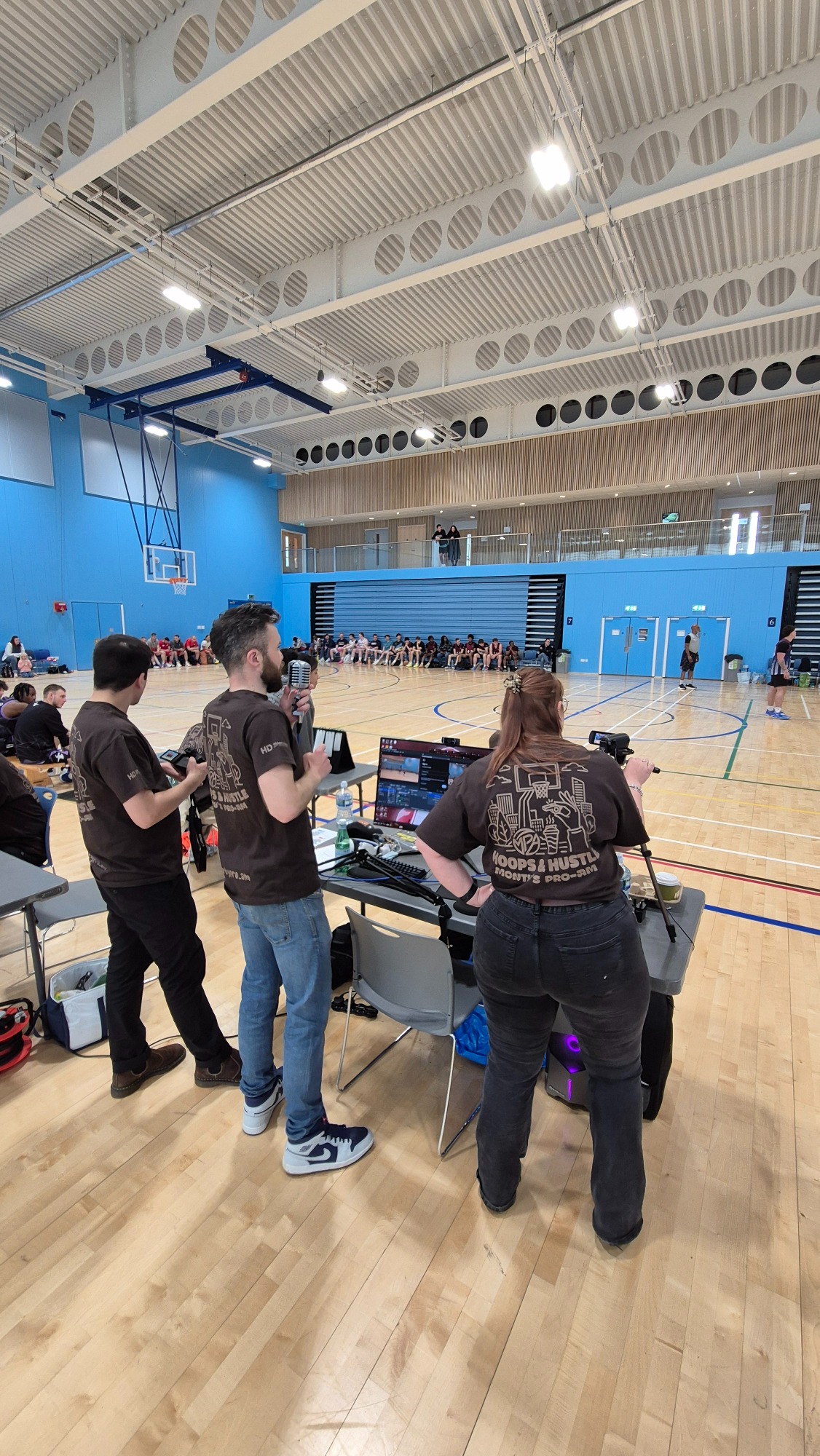 GBB Broadcasting team A team of people with broadcasting equipment in a sports hall during an event.